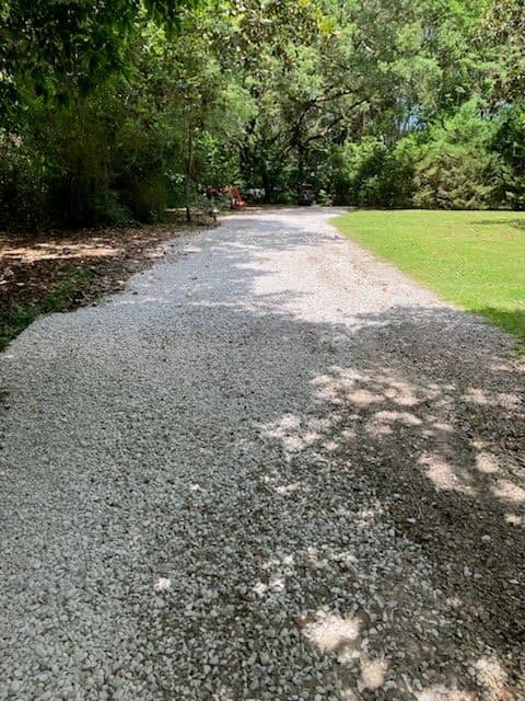 After residential driveway gravel refresh with uniform fresh gravel.