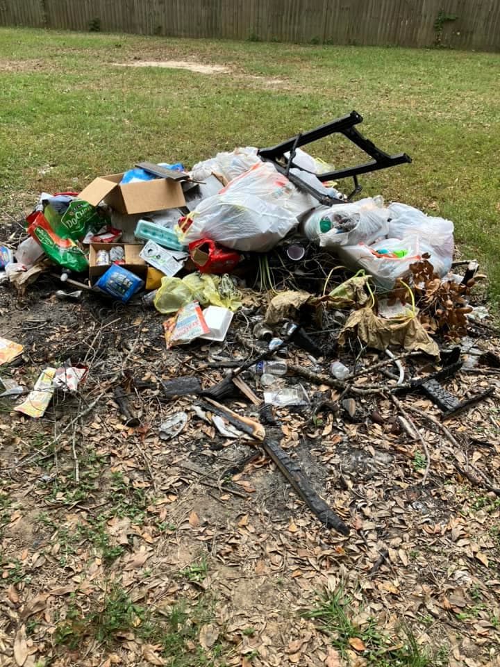 Before a small junk removal job with a trash pile in the yard.